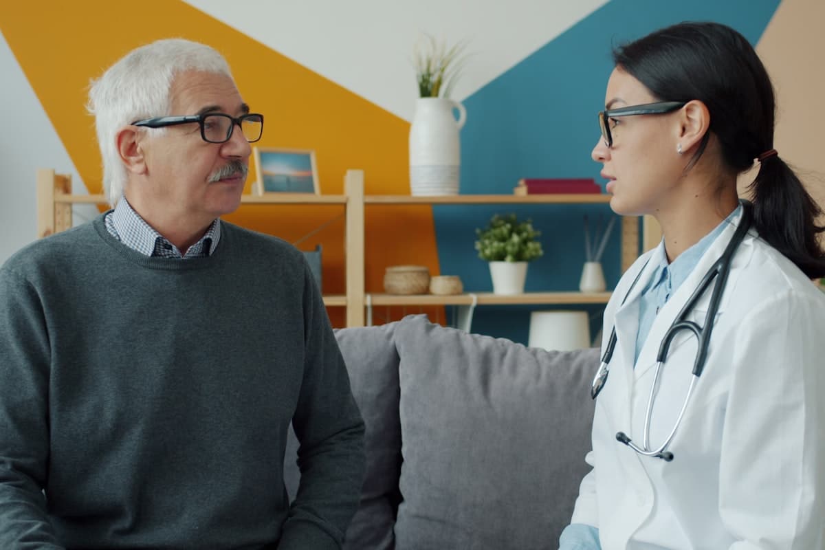 Doctor in conversation with the person in her care, at home
